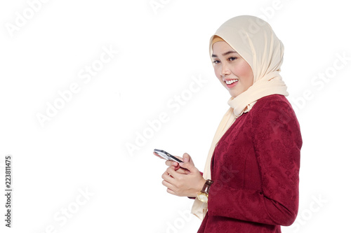 portrait of beautiful young Muslim woman using a mobile phone with a smile on a white background
