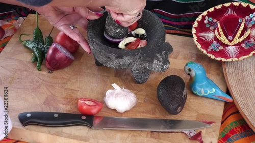 Making mexican salsa in a traditional way with molcajete
