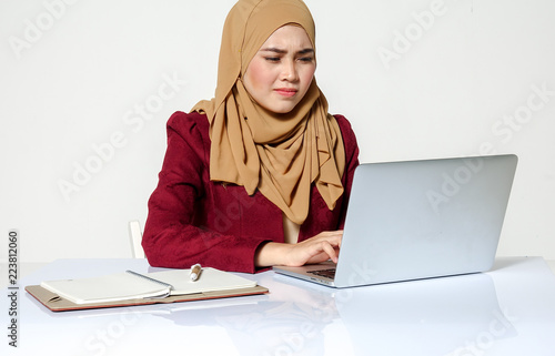 Portrait of pretty Asian hijap woman in front of laptop photo