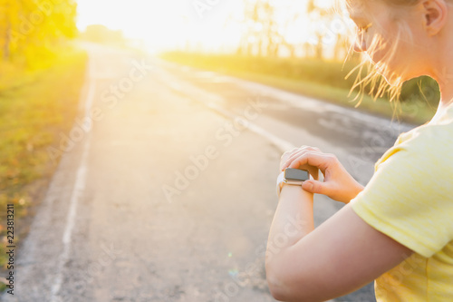 Smartwatch woman athlete using smart watch activity tracker gps during running training.