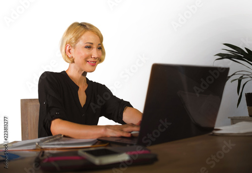 corporate business portrait of young beautiful and happy woman with blonde hair smiling while working relaxed at office laptop computer desk isolated on white