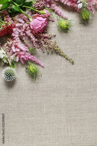 Bunch of pink flowers and plants on linen background