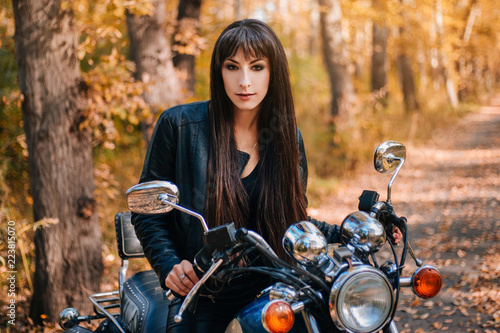 Girl on a motorcycle in a black jacket and leather pants. Women biker © Вероника Преображенс