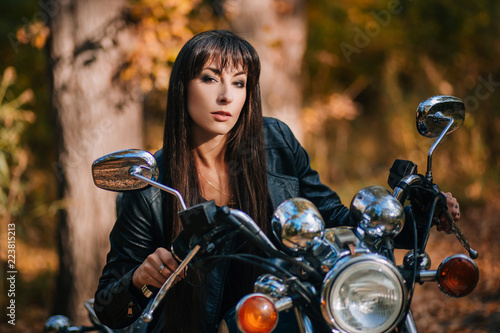 Girl on a motorcycle in a black jacket and leather pants. Women biker