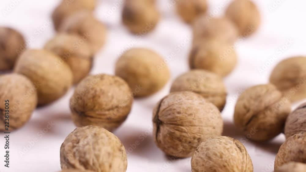Fresh walnuts on white textured surface. Close up. Fresh walnuts on white textured surface. Close up.