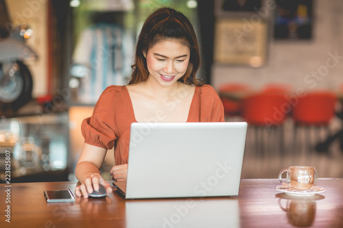 Beautiful Attractive Business Asian woman working with laptop and looking in monitor smile and have positive emotional feeling so happiness,Business Startup Concept,Warm Tone