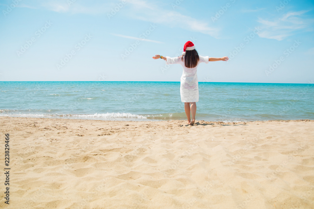 Christmas vacation. Christmas beach vacation travel woman wearing Santa hat and bikini enjoying christmas on tropical beach. woman in santa hat and bikini. toned Christmas vacation. Christmas beach vacation travel woman wearing Santa hat and bikini enjoying christmas on tropical beach. woman in santa hat and bikini. toned