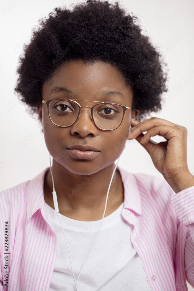 Fototapeta premium good looking student in stylish shirt taking off earphones. close up portrait, clothes, fashion concept