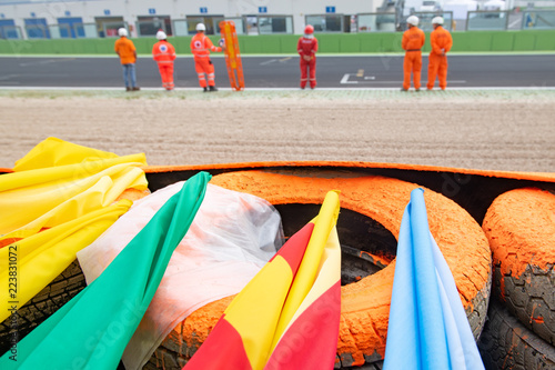 Φωτογραφία Motor sport warning flags close up on racing circuit barrier