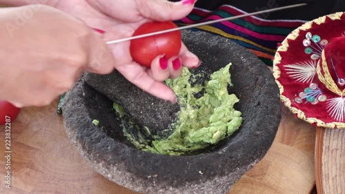cutting tomatoes making guacamole in mexican molcajete