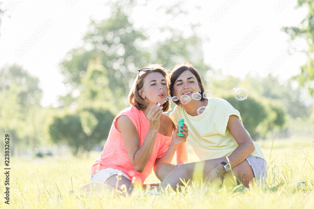 Two girl laughing on grass Two girl laughing on grass