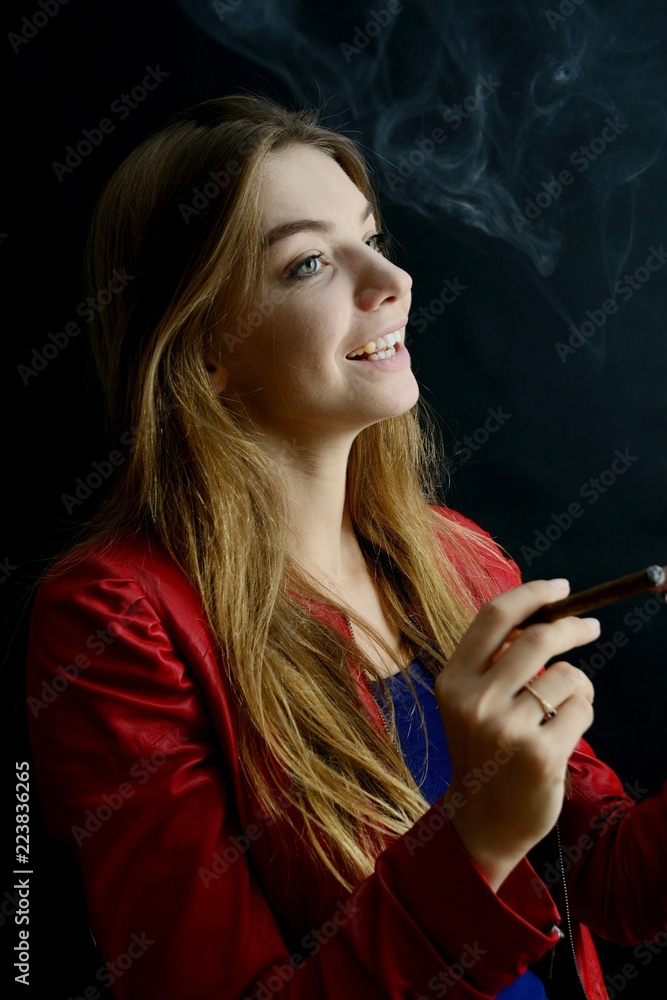 Fototapeta premium Young female smoking cigarillo