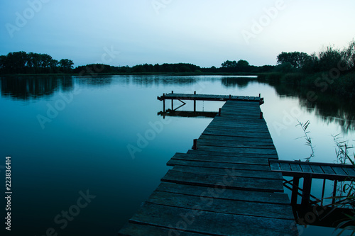 Fototapeta Naklejka Na Ścianę i Meble -  Wooden jetty over a calm mystical lake