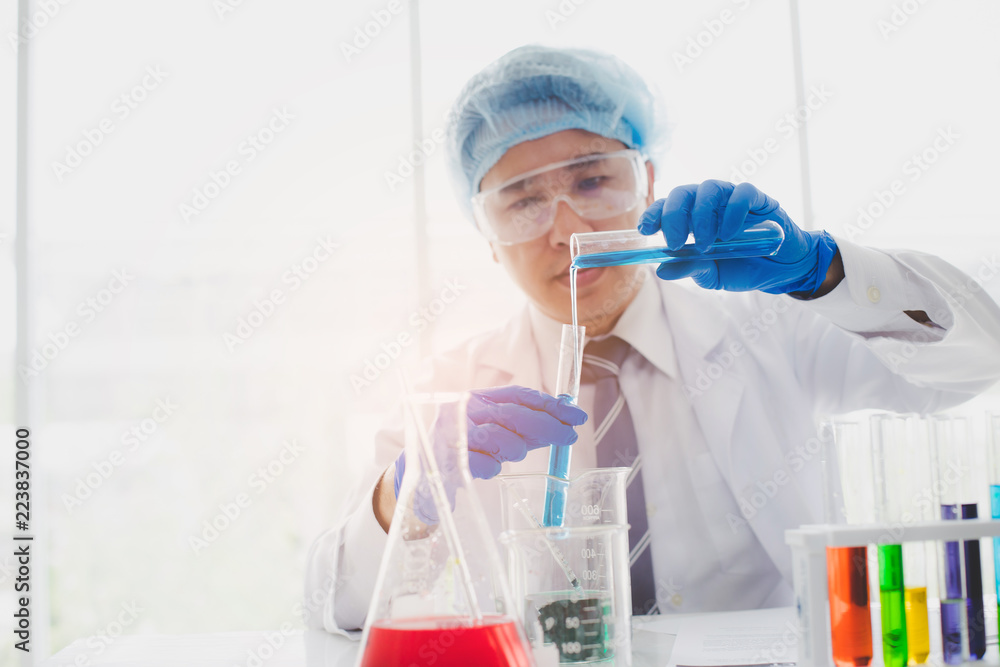Scientist or researcher is looking at a liquid sample in a test tube with a pipette. Science, chemistry, biology concept. Scientist or researcher is looking at a liquid sample in a test tube with a pipette. Science, chemistry, biology concept.