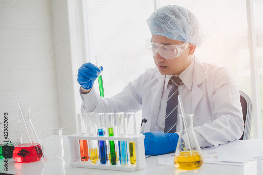 Senior scientist are examining the results with a test tube in a science lab. Researcher working in the laboratory. Senior scientist are examining the results with a test tube in a science lab. Researcher working in the laboratory.