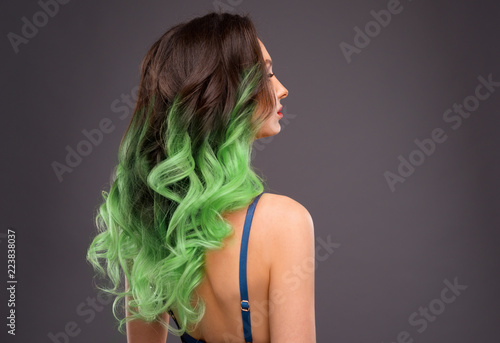 Woman with Long Healthy Colorful Green Ombre Wavy Hair. Close Up of Hairstyle. Care and Hair Products photo