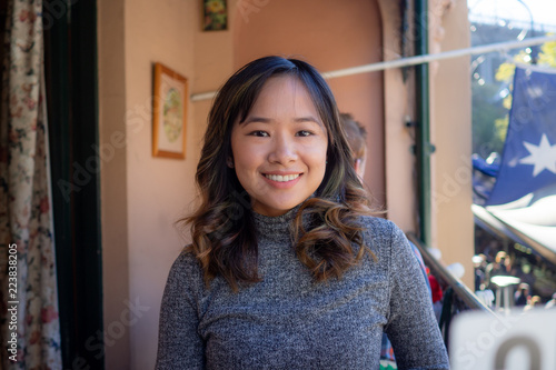 Young woman cheerfully sitting outside on a nice day