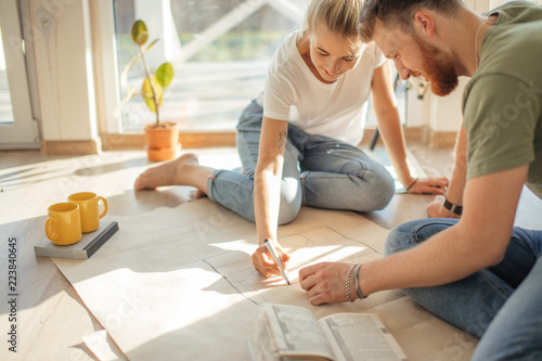 Portrait of happy caucsian couple planning new house design looking at paper