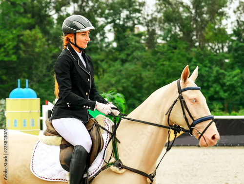 Foto Beautiful girl and horse in jumping show, equestrian sports