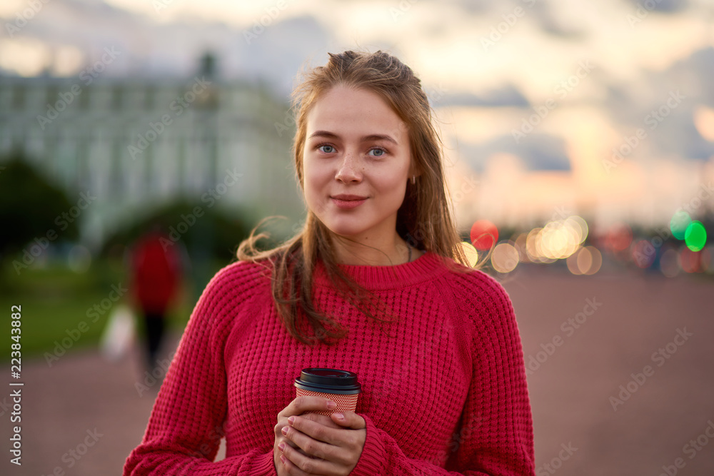 Red-haired girl drinking coffee. Beautiful woman resting in the fresh air, enjoying the sunset. Red-haired girl drinking coffee. Beautiful woman resting in the fresh air, enjoying the sunset.