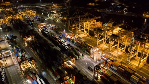 Aerial hyperlapse - Night shot of busy industrial port. Footage of seamless transport routes supply chain