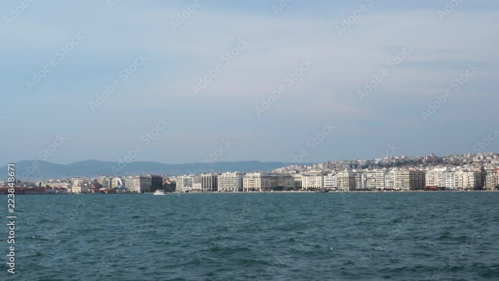 Cloudy blue summer sky over calm sea in big ancient Greece port city Thessaloniki modern hotel infrastructure seafront Cloudy blue summer sky over calm sea in big ancient Greece port city Thessaloniki modern hotel infrastructure seafront