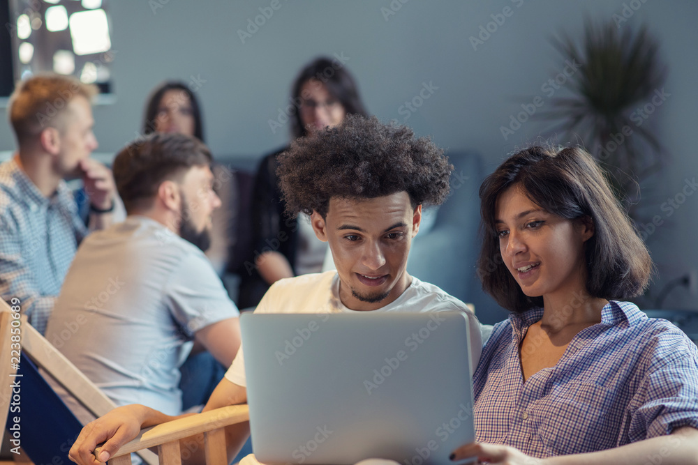 startup business and new mobile technology concept with young multiethnic couple in modern bright office interior working on laptop and tablet computer on new creative project and brainstorming startup business and new mobile technology concept with young multiethnic couple in modern bright office interior working on laptop and tablet computer on new creative project and brainstorming
