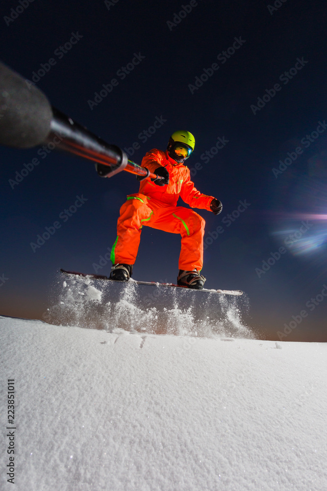 Snowboarder making a selfie by his action camera on the top of the ski slope