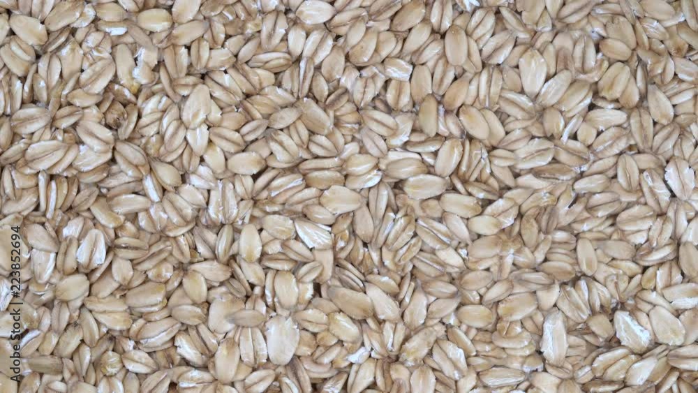 Dry oat flakes grains background, close up rotation loopable 4k top view. Food background. Gastronomy concept, organic food. Macro rotation oat flakes Dry oat flakes grains background, close up rotation loopable 4k top view. Food background. Gastronomy concept, organic food. Macro rotation oat flakes