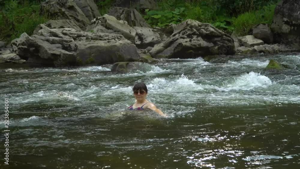Woman bathing in the river. A young nice woman is bathed in a clean mountain river. She is happy. Woman bathing in the river. A young nice woman is bathed in a clean mountain river. She is happy.
