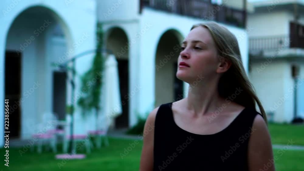 Dreamy attractive young blonde girl having a nice relaxing walk around beautiful white buildings looking around Dreamy attractive young blonde girl having a nice relaxing walk around beautiful white buildings looking around