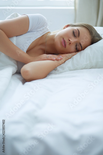 Beautiful young blonde woman sleeping in bed