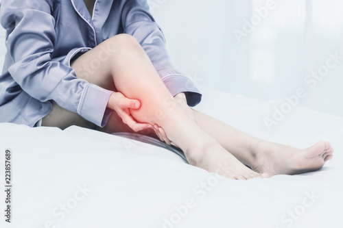 women lag pain on bed in bed room in the morning.