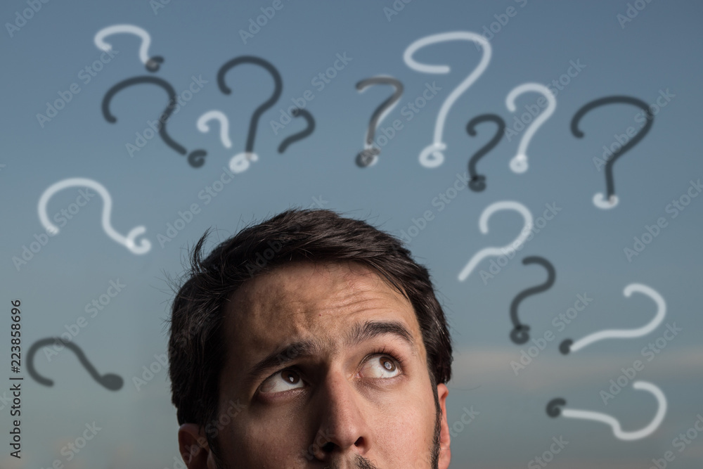 Portrait of young man with expression of doubts, questions