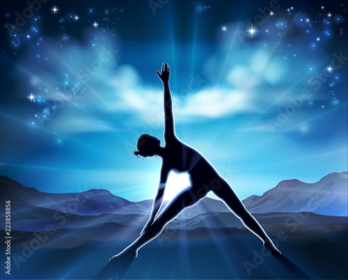 A woman in a yoga or Pilates position in silhouette with the sunrise behind her background concept