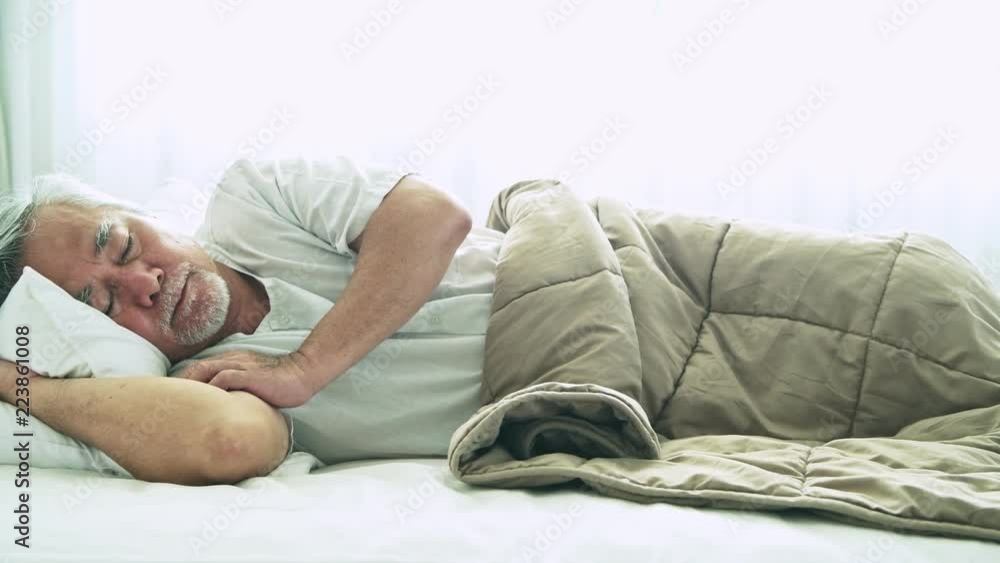 Senior man sleeping in bed. Old asian man sleeping comfortably in bed with curtain open. Senior lifesyle concept. Slider shot. Senior man sleeping in bed. Old asian man sleeping comfortably in bed with curtain open. Senior lifesyle concept. Slider shot.