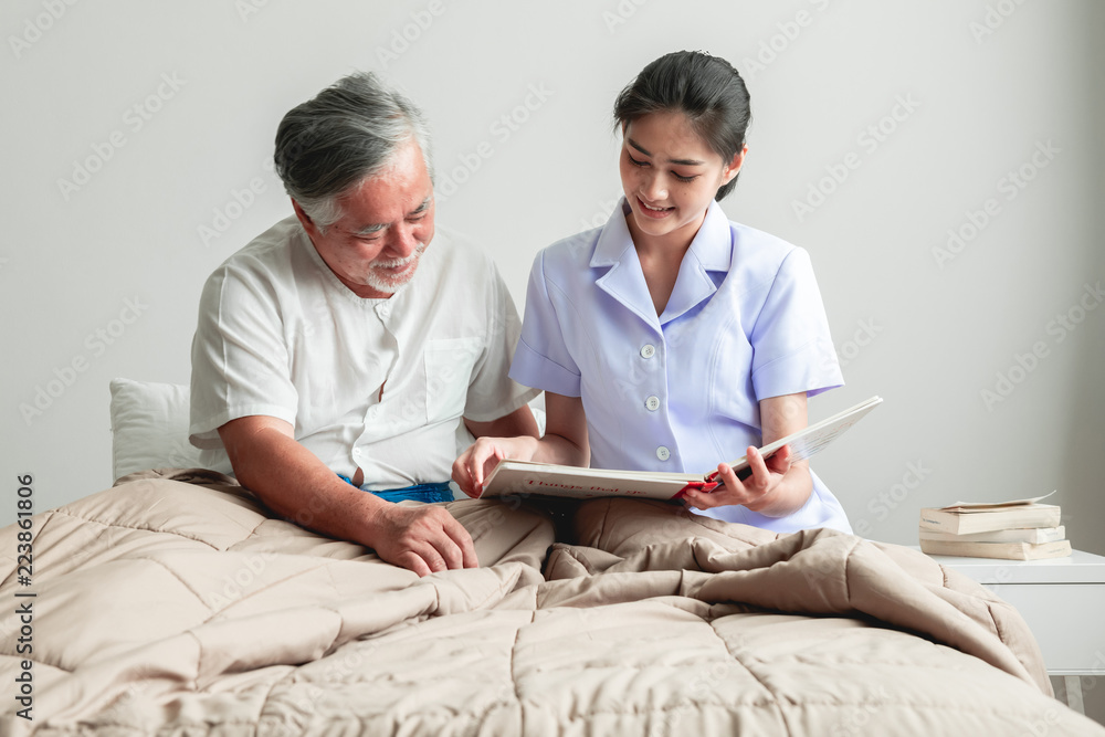 Young beautiful female nurse reading book to senior man. Young beautiful female nurse reading book to senior man.