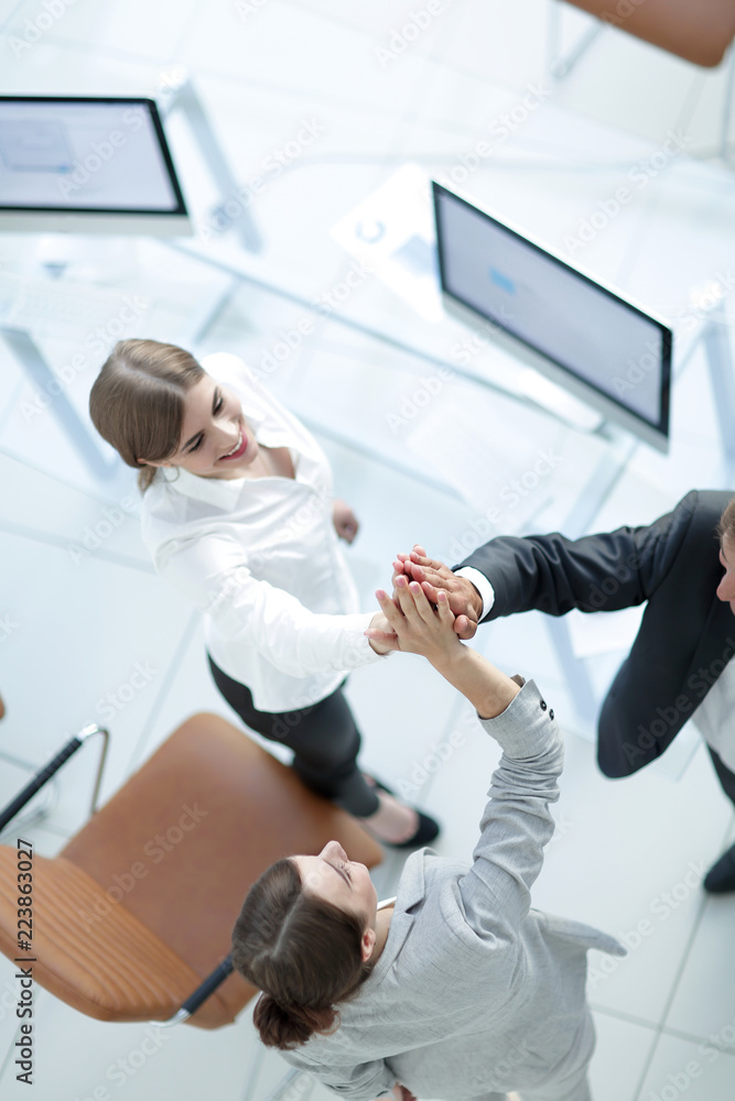 view from the top.members of the business team giving each other a high five above the Desk. view from the top.members of the business team giving each other a high five above the Desk.