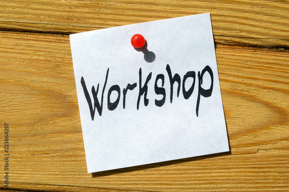 Workshop written on Sticky note and posted on wooden background