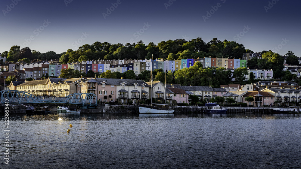 The sun is setting over Bristol Harbour lighting the colourful terrace of houses