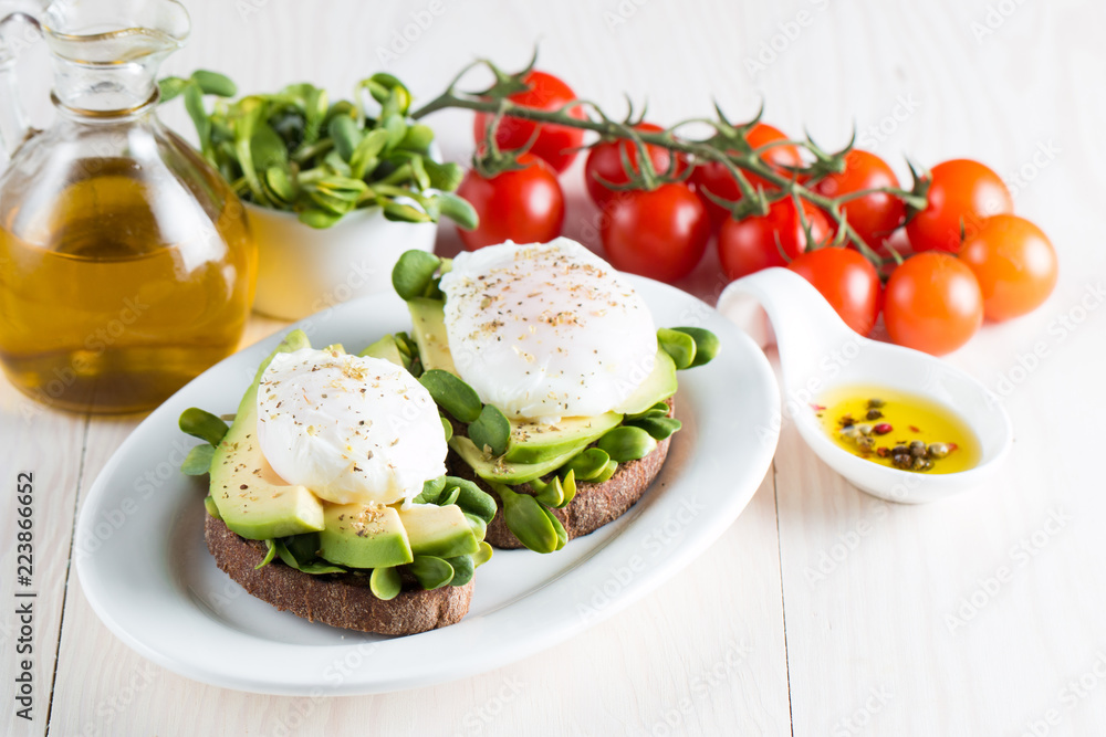 Avocado toast, cherry tomato on wooden background. Breakfast with toast avocado, vegetarian food, healthy diet concept. Healthy sandwich with avocado and poached eggs. Avocado toast, cherry tomato on wooden background. Breakfast with toast avocado, vegetarian food, healthy diet concept. Healthy sandwich with avocado and poached eggs.