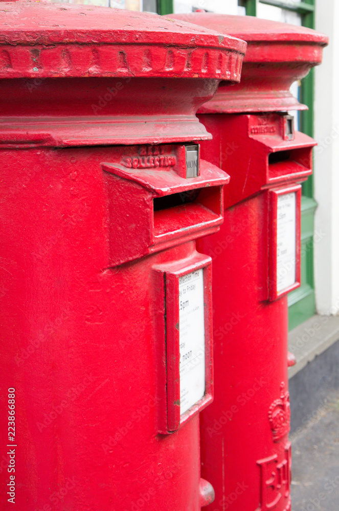Closeup of two traditional British red mail boxes.