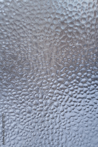 Frozen water drops on the winter window as background. 