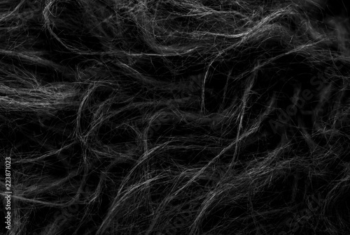 Black soft natural animal wool texture background. Skin wool. Close-up texture of dark fluffy fur. Gray plush photo