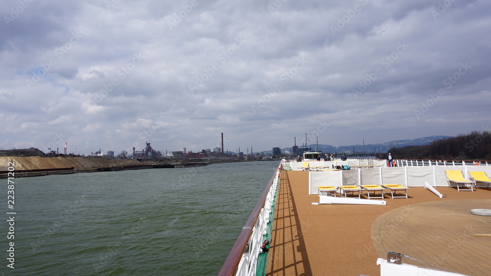 Obraz premium Linz an der Donau, Industriehafen und Brücken, fotografiert von einem Flusskreuzfahrtschiff im Frühjahr