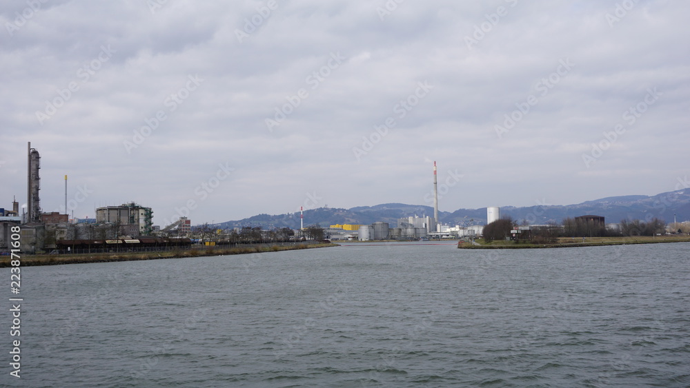 Linz an der Donau, Industriehafen und Brücken, fotografiert von einem Flusskreuzfahrtschiff im Frühjahr