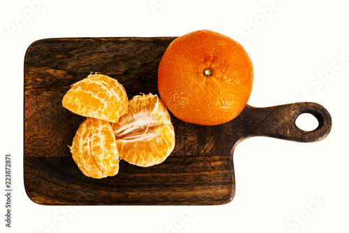 Mandarin - whole fruit and cantles on wooden board. Top view. Isolated on white.
