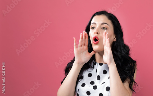 Young woman shouting on a solid background photo