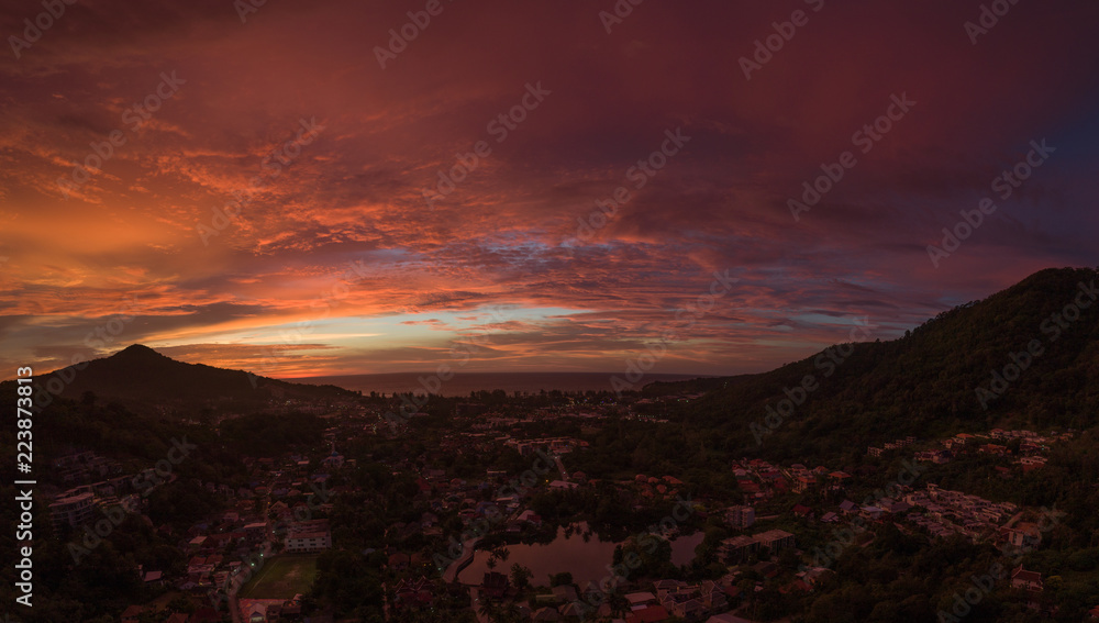 Aerial drone view of amazing dramatic sky during sunset. Island's city view under the clouds at sundown