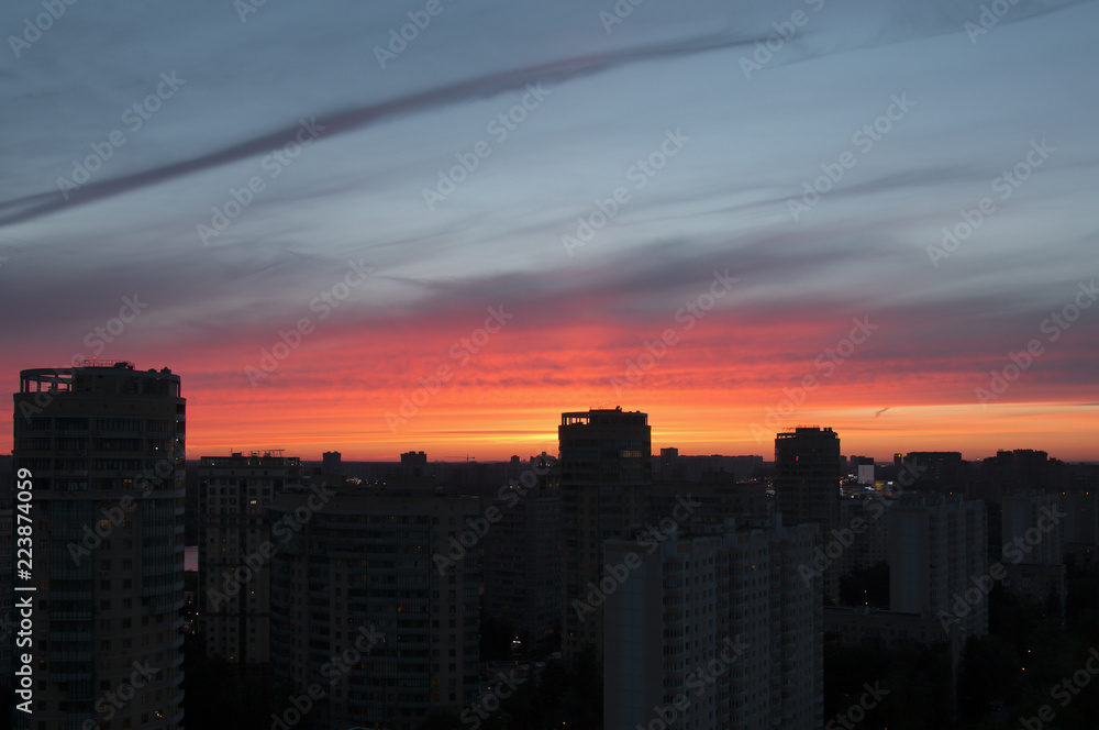 Mystical purplish red sunset over the dark silhouette of city